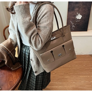 Gros plan du sac cabas taupe avec boucles argentées et détails à plusieurs poches