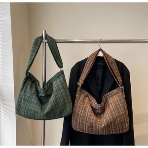 Detailed view of forest green and retro brown plaid tote bags hanging for display