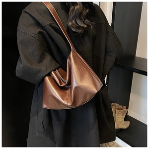 Rear view of brown glossy leather shoulder bag worn by model for daily commute style
