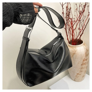 Close-up of black leather hobo bag with silver zipper and adjustable buckle strap detail