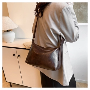 Detail of dark brown leather texture and silver buckle on the vintage hobo bag