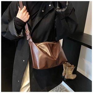 Detailed view of dark brown vintage faux leather tote bag with glossy finish and buckle