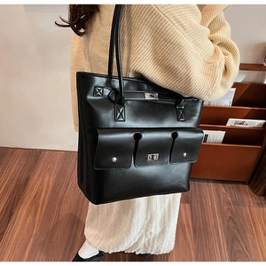 Détails du sac cabas en cuir noir avec fermoirs argentés et deux poches avant plaquées