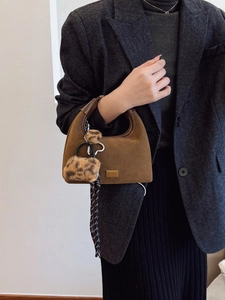 Brown suede hobo bag with leopard charms and scarf accent on a gray wool blazer