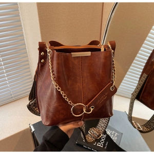 Détails du sac seau vintage marron avec bandoulière brodée et chaîne dorée