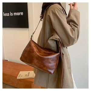 Detail of a brown vintage oil wax leather pillow bag with adjustable shoulder strap