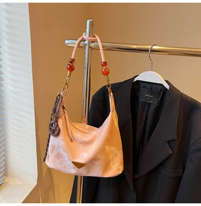 Detailed shot of pink marble hobo bag with luxury beaded handle on a metal hanger