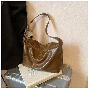 Detailed view of deep brown retro hobo bag with glossy synthetic leather texture