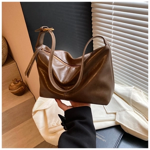 Macro shot of deep brown vintage oily leather bag texture with golden buckle detail