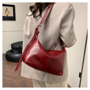 Detail view of large dark red hobo bag with adjustable strap and silver metal buckle