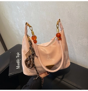Close-up of pink nylon hobo bag with iconic triangle logo and beaded strap details