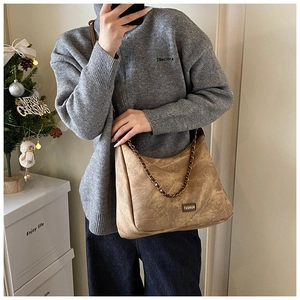 Close-up of vintage brown washed leather tote bag with thick metal chain shoulder strap