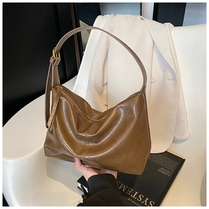 Detailed macro view of caramel leather texture and gold metal zipper on large tote bag
