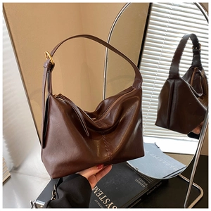Detail of dark brown vintage hobo tote bag with soft leather texture and golden buckles