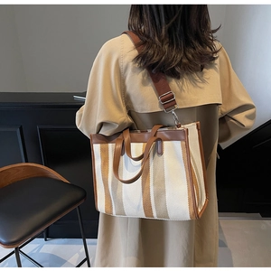 Detailed view of large canvas tote bag with brown stripes and adjustable shoulder strap
