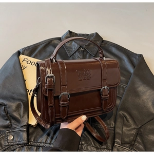 Detail of dark brown vintage briefcase bag with elegant metal buckles and embossed logo