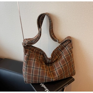 Detail of vintage brown plaid hobo bag featuring thick tweed texture and adjustable strap