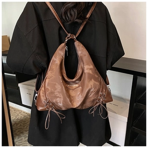 Close-up of brown leather Hobo backpack with drawstring details and brand logo