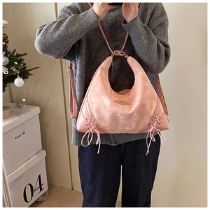 Detailed view of pink tie-dye hobo bag with ribbon bows and multi-way straps