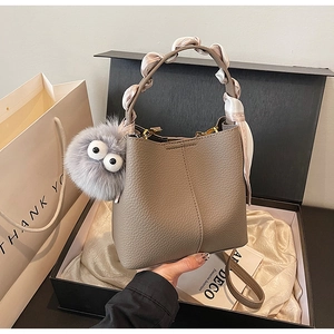 Gray lychee grain bucket bag with silk scarf handle and monster charm in a luxury gift box