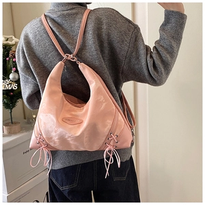 Detail of pink Hobo bag with lace-up bow knots and spacious dual-strap design