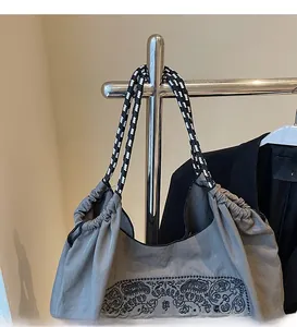 Detail of grey ethnic tote bag featuring woven rope handles and paisley print design