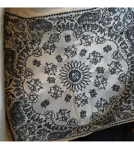Close-up of ethnic paisley embroidery and floral patterns on cream fabric tote bag