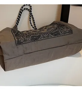 Detail view of large tote bag with paisley print and woven rope shoulder straps
