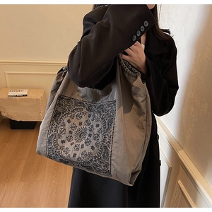 Detail of taupe paisley tote bag with mandala print on canvas texture with soft lighting
