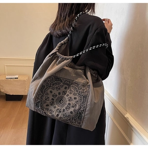 Detailed side view of ethnic tote bag featuring intricate mandala and paisley patterns