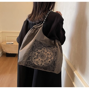 Close-up of vintage paisley tote bag with woven handles and drawstring closure detail