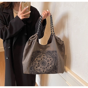 Detail of vintage tote bag featuring ethnic pattern, drawstring and woven rope handles