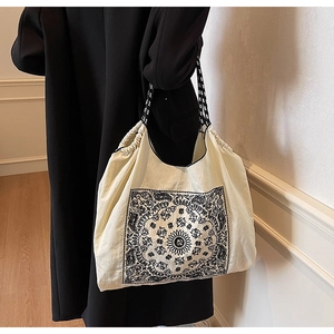 Detail of bohemian tote bag with black paisley print and rope-style shoulder strap