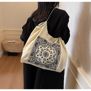 Detail of retro paisley print tote bag with woven shoulder strap and gathered top edge