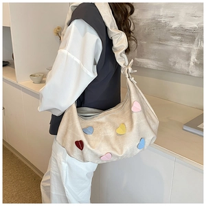 Detail of hobo shoulder bag with colorful leather heart patches and ruched strap design