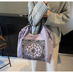 Detail of purple tote bag with bohemian prints and woven shoulder strap on model