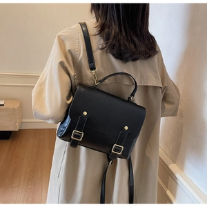 Model wearing a vintage black PU leather messenger bag with adjustable shoulder strap