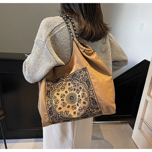 Detailed back view of a camel drawstring tote bag with mandala prints and woven straps