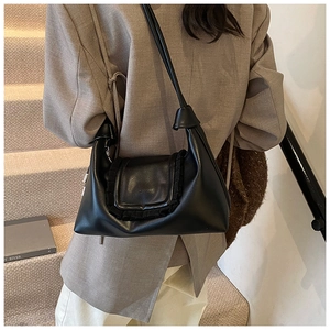 Close-up of a black pleated dumpling bag with elegant ruffles and shoulder strap