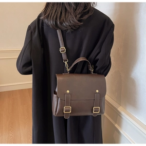 Deep brown vintage leather bag shown on model with adjustable crossbody strap in minimalist setting
