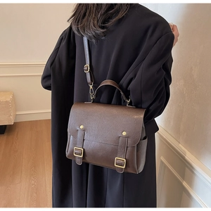 Detail of dark brown vintage faux leather backpack with gold buckle and adjustable strap