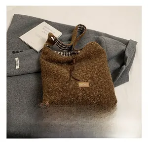 Détail de la texture en peluche marron et de la doublure à carreaux du sac cabas