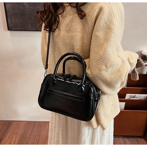 Polished black mini square handbag with dual handles and thin adjustable strap