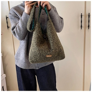 Détail du sac hobo en fausse fourrure verte avec doublure écossaise et étiquette cuir