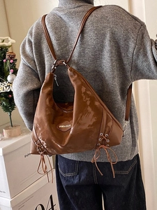 Large dark brown vintage tote bag in glossy leather shown as a versatile backpack