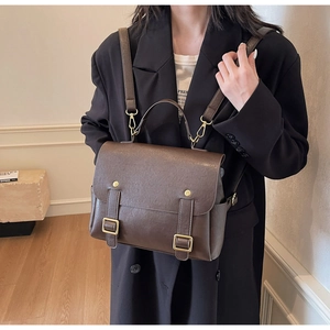 Detail of vintage brown leather backpack showing gold hardware and adjustable straps