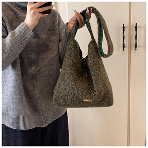 Gros plan détaillé d'un sac cabas en peluche vert foncé avec une texture polaire douce