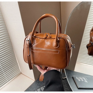 Detail of caramel oil-wax leather handbag with double handles and adjustable shoulder strap