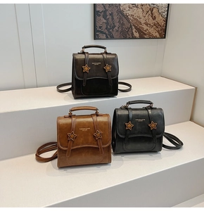 Detailed close-up of retro leather backpacks in multiple colors with star ornaments