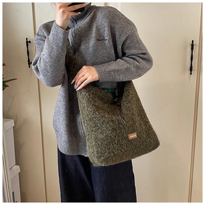 Vue détaillée du sac cabas en peluche vert foncé avec étiquette en cuir